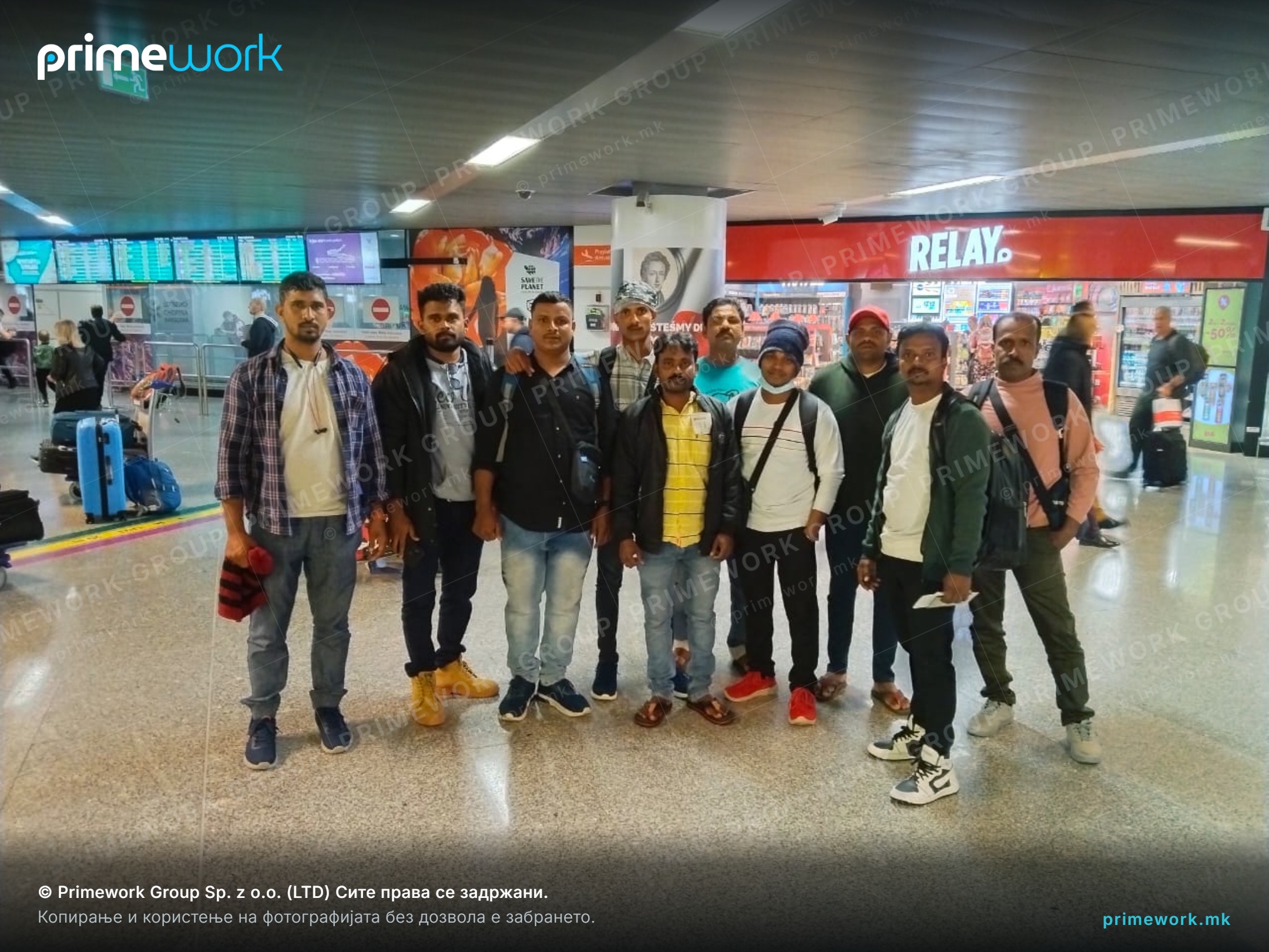 A group of Indian workers with luggage in the arrivals hall after landing