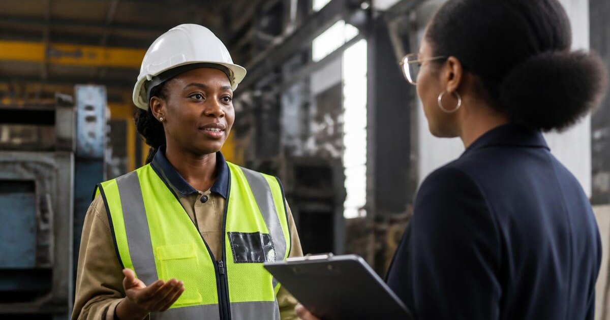 An African worker in a helmet and vest next to a recruiter holding documents – Primework Group article graphic