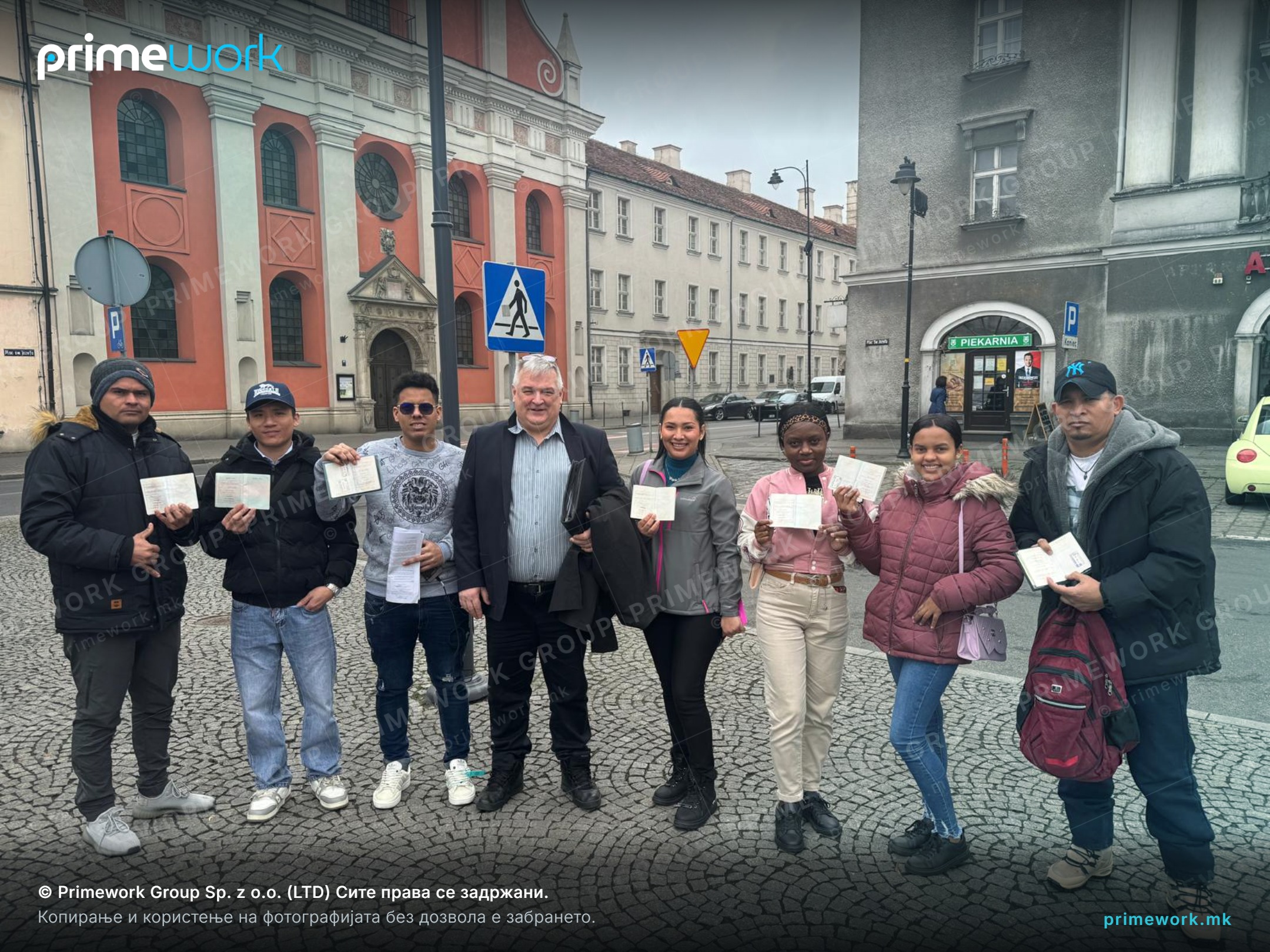 A group of Indian workers holding residence documents on the street