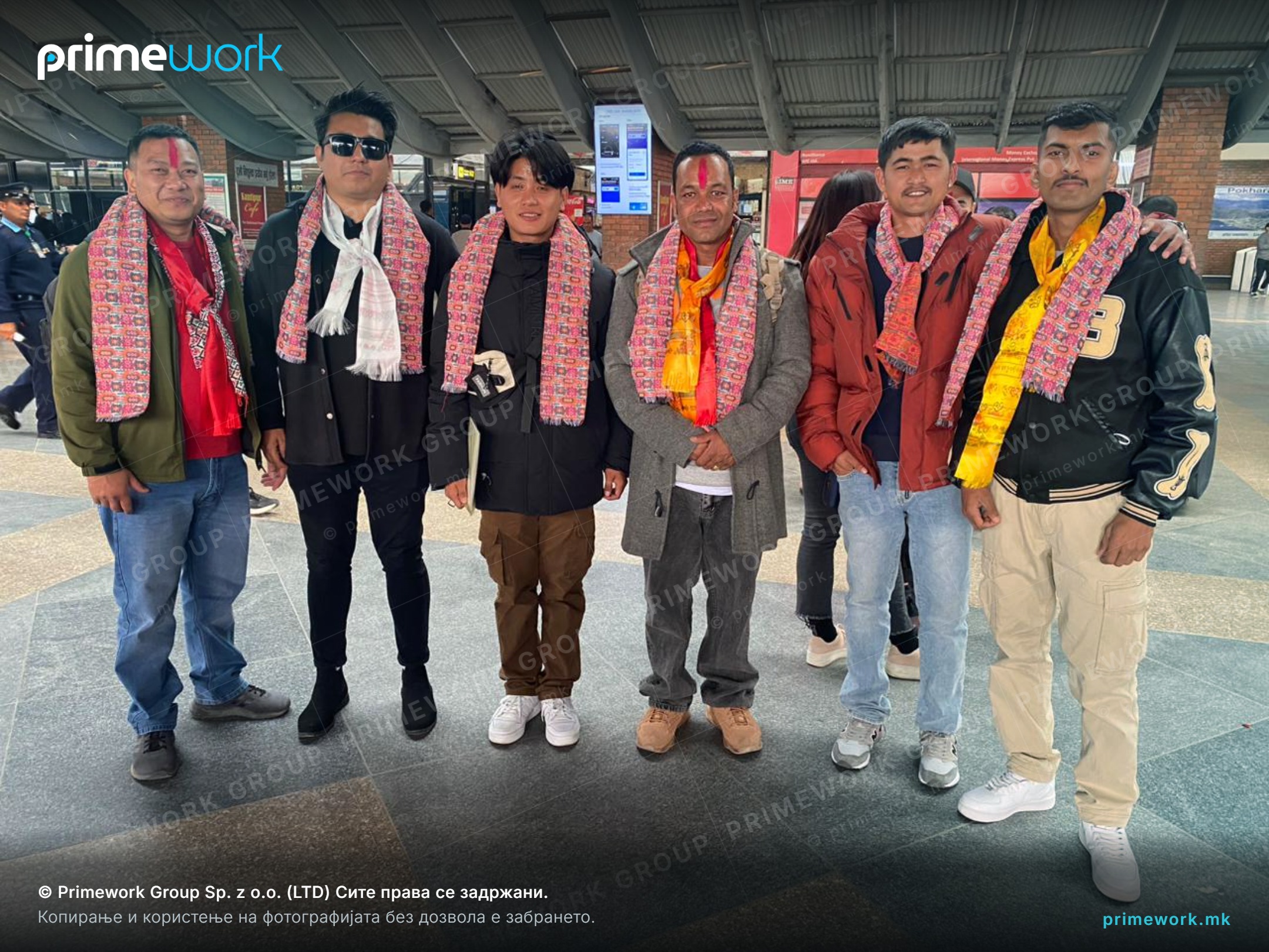 A group of Nepali workers with traditional scarves before departing for work